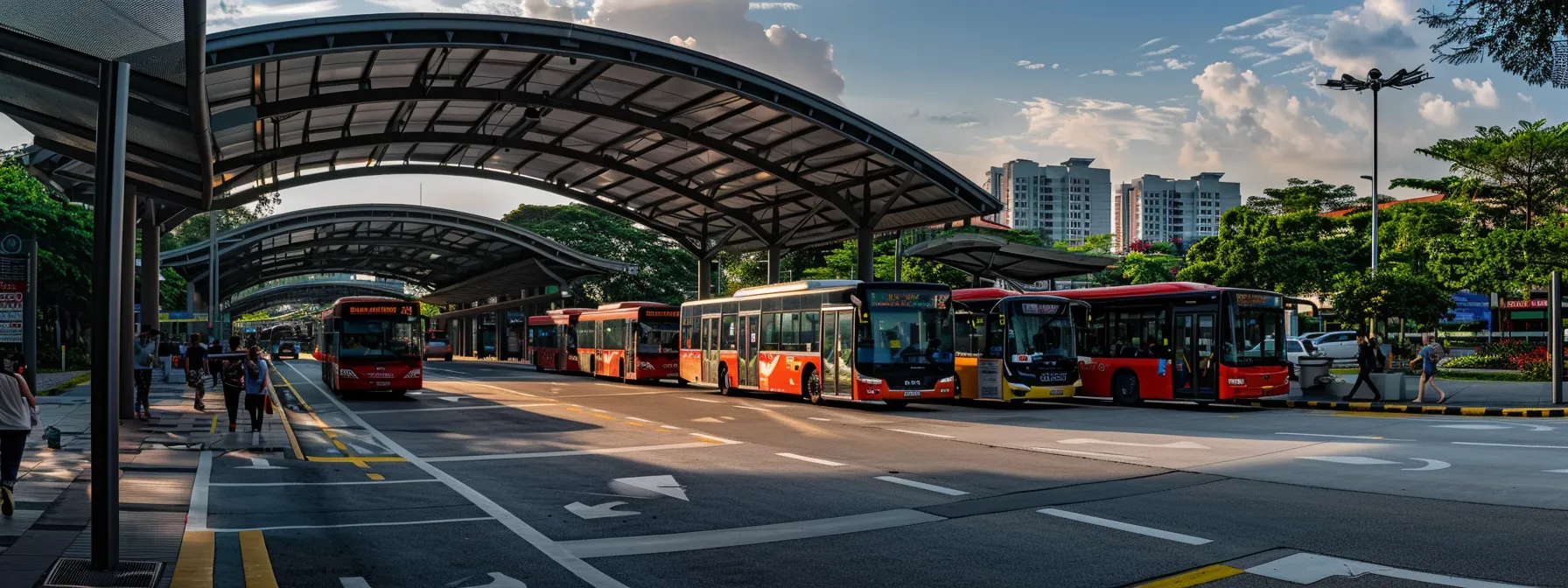 a bustling bus interchange in tampines, with buses loading and unloading passengers under a covered roof, showcasing the excellent connectivity and transportation options in the area.